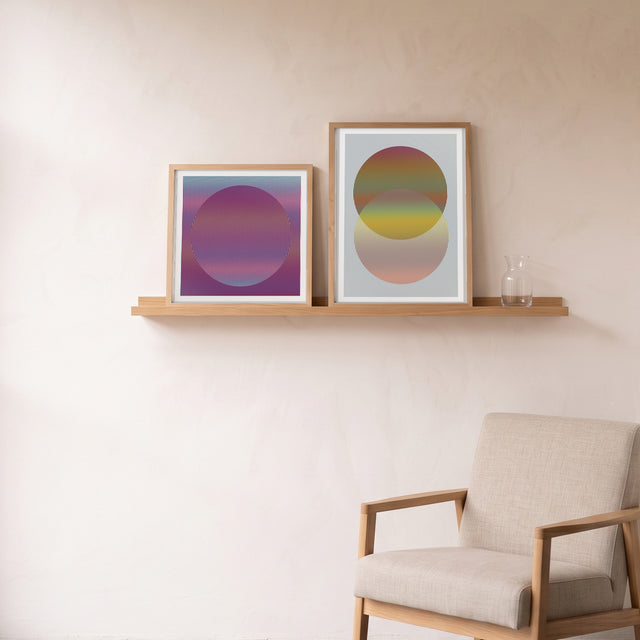 Geo Lines C framed on an oak picture shelf beside a linen armchair – art print by Marcio Pontes
