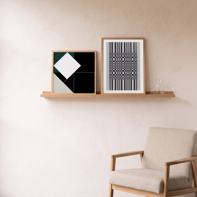 Fineline Balance II framed on an oak picture shelf beside a linen armchair – art print by Marcio Pontes