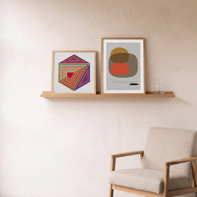 Stones III framed on an oak picture shelf beside a linen armchair – art print by Marcio Pontes