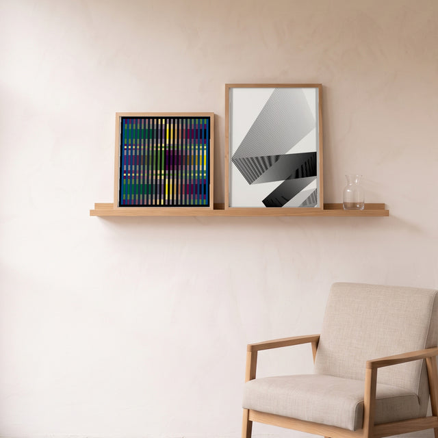 Black Lines 1 framed on an oak picture shelf beside a linen armchair – art print by Marcio Pontes