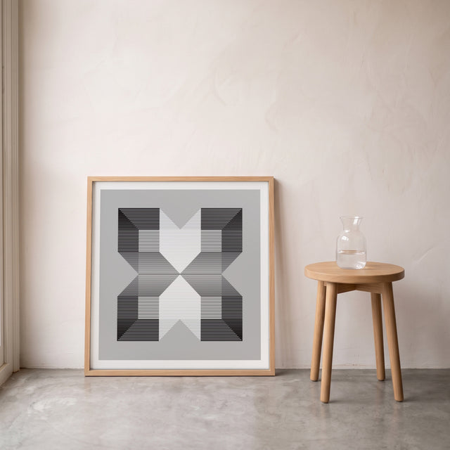 Geo Cube B&W I framed leaning against the wall on a concrete floor – art print by Marcio Pontes