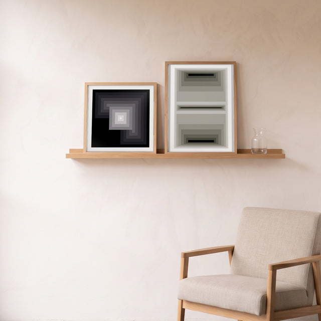 Minimal Grey framed on an oak picture shelf beside a linen armchair – art print by Marcio Pontes