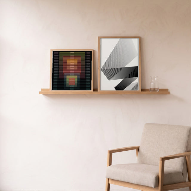 Underline 10 framed on an oak picture shelf beside a linen armchair – art print by Marcio Pontes